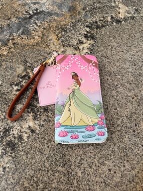 This is a Loungefly Disney Princess and the Frog Tiana Bayou Sunset Tech Wallet